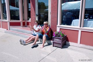 L.- R. Mary Winn and Mary Stenbroten enjoying the music and weather on Main St. in front of the restaurant at 209 Main St.